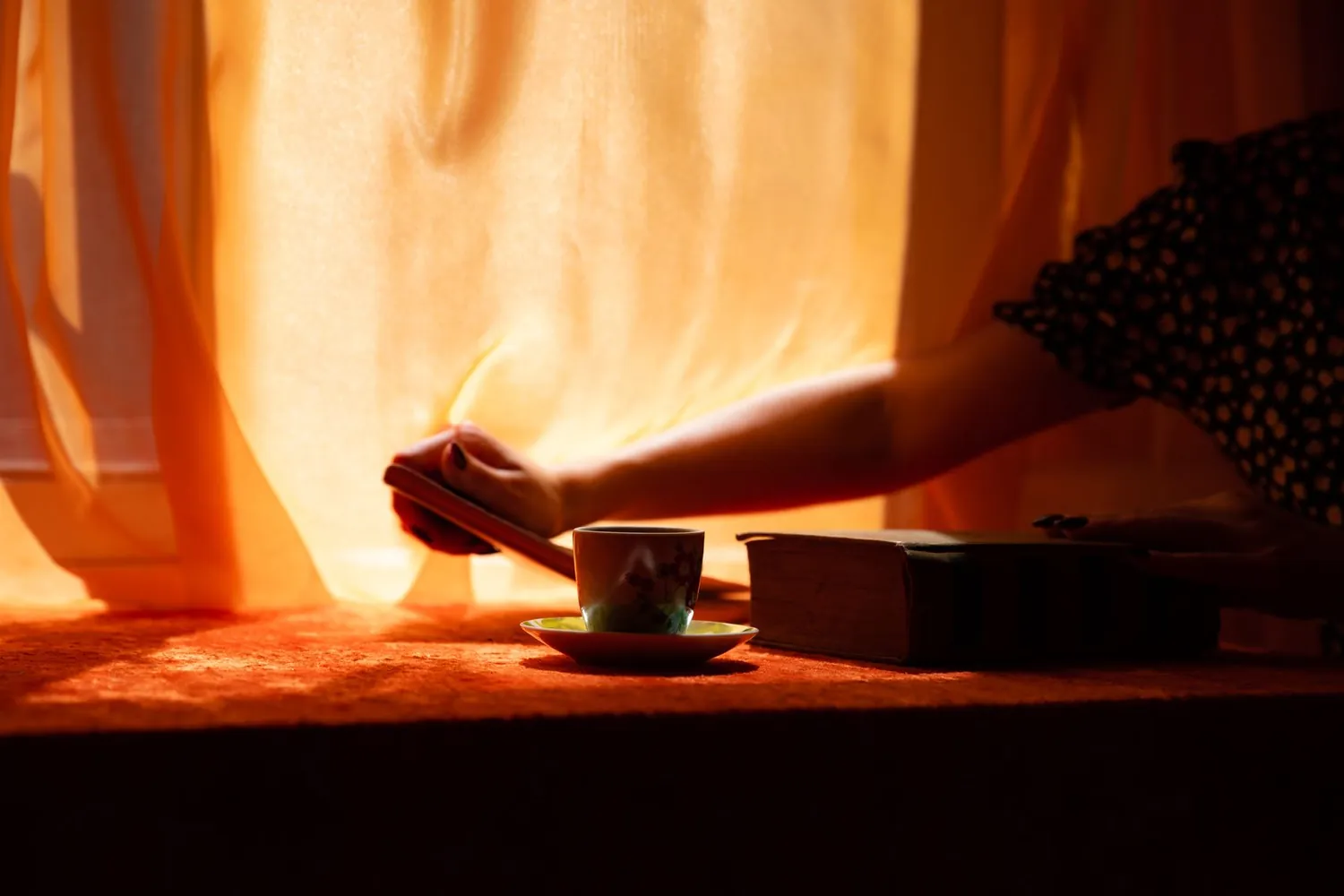 Morning light coming through the curtains with a cup of tea